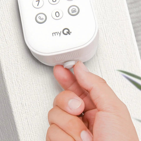 Hand installing Two Piece Security Quick Thumb Screws Designed For MyQ Smart Garage Door Video Keypad on wall.