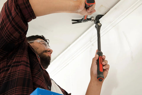 Man using an 18 Inch Indexing Flat Pry Bar With 15 Locking Positions Raised Striking Surface For Hammer Or Mallet Use Dual Material Grip