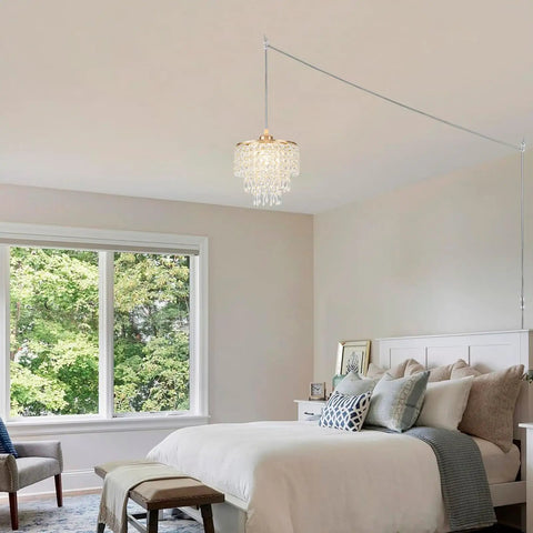 Straight Up Gold Plug In Pendant Light With 16 Foot Long Cord And Sparkling Three Tier Crystals For Kitchen Island Or Cozy Bedroom Setup Premium Slick Mini Chandelier Drip hanging above a bed in a cozy room.
