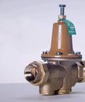 Side view of Watts LF25AUB-Z3 water pressure reducing valve, brass body, 3/4 inch NPT female unions.