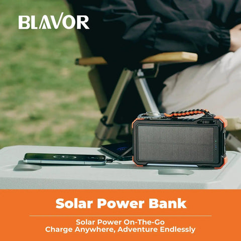 Beast Power Bank 20000mAh with built-in cables next to a smartphone, on a table outdoors, emphasizing portability during travel.