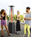 Group of people around a tall four-sided outdoor liquid propane patio heater with visible replacement glass tube