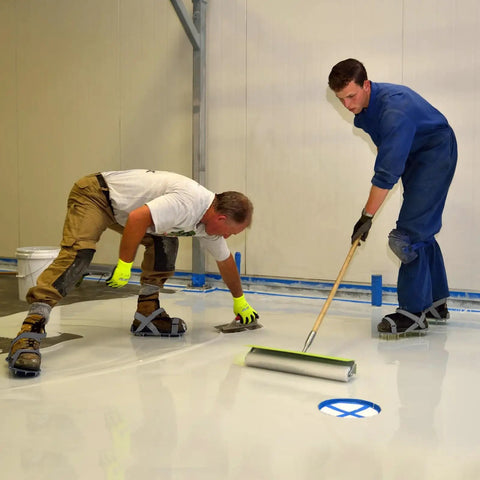 Two workers applying epoxy floor coating wearing Epoxy Floor Spiked Shoes For Garage Fully Assembled Gunite Shoes with 3/4 inch spikes