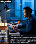 Lithium Orotate 20 Mg Complex Capsules With Magnesium Glycinate And Ashwagandha For Sharp Focus Memory And Mood Boost Brain Health Supplement bottle next to person at desk.