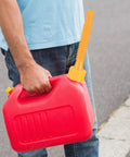 Red gas can with Gas Can Spout Replacement Kit 7 Piece Nozzle Set shown in use on a street