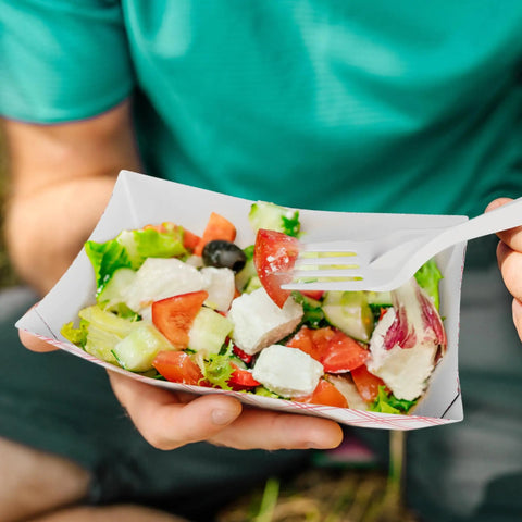 Person holding salad in Heavy Duty Red Disposable Food Trays 3lb Capacity Workhorse Bulk Pack 250 Count For Concession Stands.
