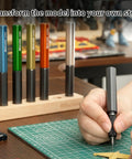 Person using Pro Grade 7 Piece Tungsten Steel Scribing Tool Set With Wooden Stand for model making, various blade sizes visible.