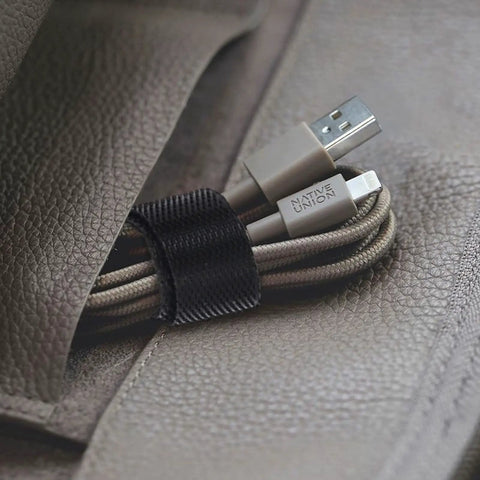 Reusable Cable Ties Organizer Set For Home Office And Tech Gear, black strap securing USB cables on textured surface