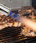 Grilled steaks being seared with a Pro Searer Kitchen Torch For Searing Meats And Fish, Sous Vide Finish, caramelizing edges.