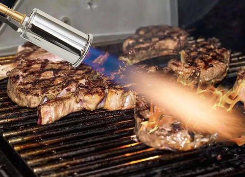 Grilled steaks being seared with a Pro Searer Kitchen Torch For Searing Meats And Fish, Sous Vide Finish, caramelizing edges.