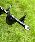 Close-up of black alloy auger spiral bit on grass, part of Auger Drill Bit Set Of 4 For Planting, Garden Spiral Earth Bits For 3/8 Inch Hex Drive Drills