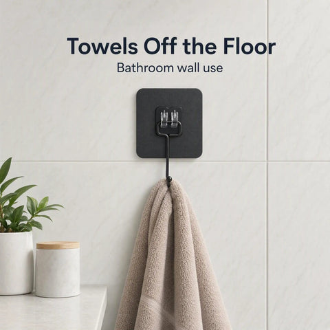 Heavy Duty Black Adhesive Wall Hooks Peel And Stick Hangers No Mess Quick Install For Entryway Keeps Counters Clear holding a towel on a bathroom wall.