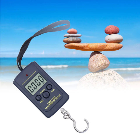 Built Tough Hella Accurate Hanging Hook Scale Portable Electronic Steelyard For Industrial Use With Solid Balance And Killer Reliability For Everyday Weighing Tasks next to balanced stones by the beach.