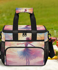Colorful insulated picnic backpack with lunch box, artistic design, sits on grass with wine glasses, snacks, and fruit nearby.