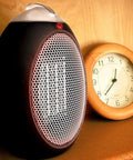 Eco Save Compact Personal Space Heater With 750 Watts ETL Listed Eco Friendly And Energy Efficient Ceramic Heating Element next to clock