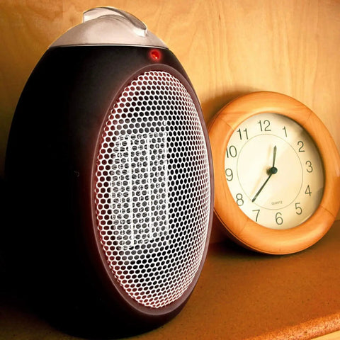 Eco Save Compact Personal Space Heater With 750 Watts ETL Listed Eco Friendly And Energy Efficient Ceramic Heating Element next to clock