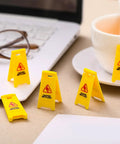 Ultimate Boss Set Of 12 Mini Wet Floor Signs Rad Tiny Yellow Caution Sign For Safety Fun And Doll Play With Durable Plastic Warning Tags Game Changer Value on a desk with coffee cup and laptop.
