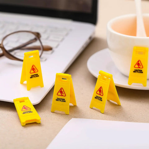 Ultimate Boss Set Of 12 Mini Wet Floor Signs Rad Tiny Yellow Caution Sign For Safety Fun And Doll Play With Durable Plastic Warning Tags Game Changer Value on a desk with coffee cup and laptop.