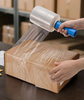 3 Pack Clear Heavy Duty Stretch Wrap Film Rolls With Handles 100 Gauge 5 X 1000 Ft thick industrial plastic cling wrapping a box.