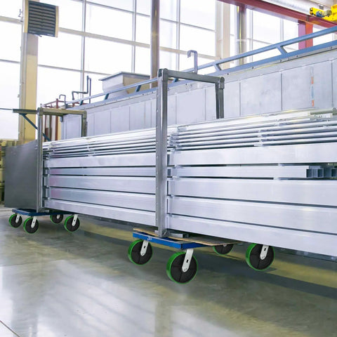 Heavy Duty Cast Iron Caster Wheels With Polyurethane Tread And Half Inch Bore Roller Bearing on a rolling cart in a warehouse setting.