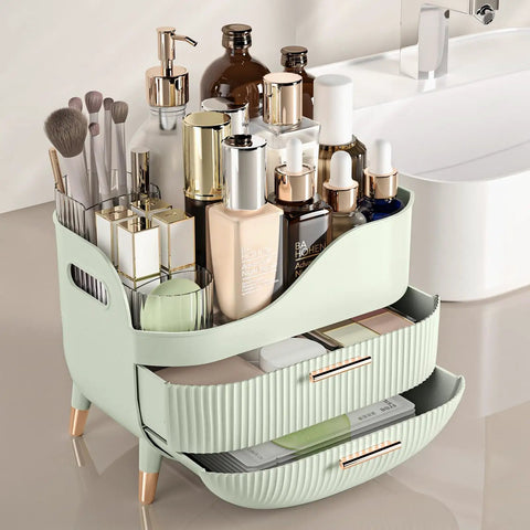 Slick Green Makeup Organizer With Two Deep Drawers And Sturdy Carry Handle, Large Skincare Storage Box For Vanity Tops filled with cosmetics.