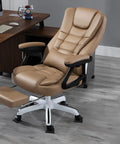 Office chair with tan leather upholstery on a grey wood floor, featuring caster wheels. Furniture setting includes a brown desk.