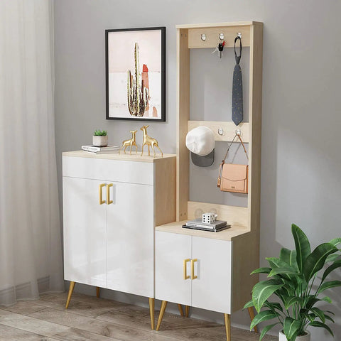 Entryway furniture with gold cabinet handles, modern white wood design, decor items, hooks, and potted plant in corner