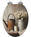 Elongated Toilet Seat Farmhouse with floral design, rustic watering can, and daisies on a wooden background.