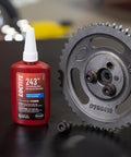 Medium Strength Surface Insensitive Threadlocker For 1/4 To 3/4 Inch Fasteners bottle next to metal gear.