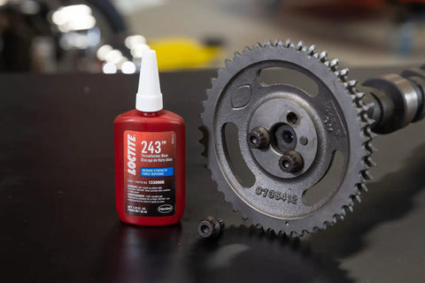 Medium Strength Surface Insensitive Threadlocker For 1/4 To 3/4 Inch Fasteners bottle next to metal gear.
