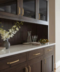 Bellamy Champagne Bronze Cabinet Pull 3-3/4 Inch Center To Center handle on dark wood cabinets in elegant kitchen setting