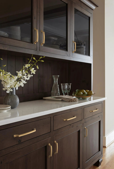 Bellamy Champagne Bronze Cabinet Pull 3-3/4 Inch Center To Center handle on dark wood cabinets in elegant kitchen setting