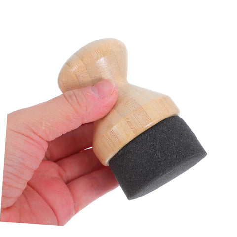Real Deal Silicone Cutting Board Oil Wax Applicator Brush For Zero Hassle Kitchen Maintenance And Wooden Utensil Care Food Grade Mineral Oil Finishing Tool Smooth Operator No Rush Setup held in hand, showing wooden handle and black sponge tip.