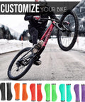 Cyclist performing a wheelie on a mountain bike with various colorful Ergonomic MTB Grips With Wrist Support For 22.2mm Bars shown below
