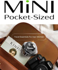 Mini pocket-sized travel gadget in leather bag with magazine and camera, ideal for men and women essentials.