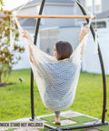 Woman sitting in a Caribbean Style Hammock Chair With Spreader Bar, XL Rope Hanging Chair for Indoor Outdoor Use, 300 Lb Weight Capacity