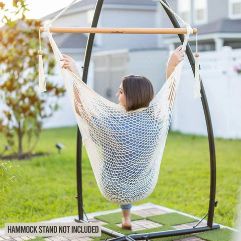 Woman sitting in a Caribbean Style Hammock Chair With Spreader Bar, XL Rope Hanging Chair for Indoor Outdoor Use, 300 Lb Weight Capacity