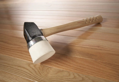 Heavy Duty Rubber Mallet With Iron White Cap for Flooring Nailers And Staplers, 4 Pound, lying on wooden floor