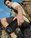 Person holding 60W Outdoor Bluetooth Speaker With IPX8 Waterproof while hiking, showcasing rugged build and portability