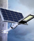 Top Shelf Solar Powered Outdoor Wall Light Featuring Smart Motion Sensor with solar panel mounted on a pole in rain.