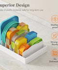 Kitchen Cabinet Lid Organizer With 6 Adjustable Dividers And 7 Sections For Lids Bowls And Containers Space Saving No Fuss Lid Holder For Pantry Fits Small To Large Containers 13 By 10 Inch shown holding various colored lids.