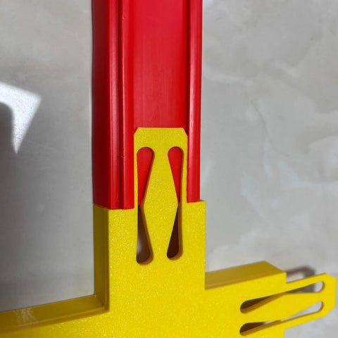 Close-up of Ultimate Cross Shape Racetrack Connector Kit For Hot Wheels Fans with red and yellow plastic intersection