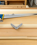 Stainless Steel L Shape Shelf Brackets For Wood Shelves And Tables Adjustable Slot Design next to a handsaw on a workbench.