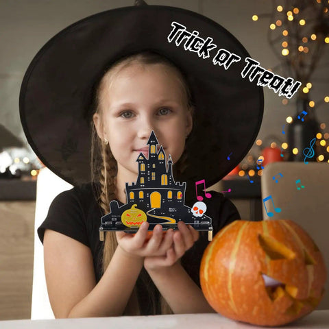 Child holding Halloween Music Castle Soldering Kit For Teens And Adults With Dual Lighting Modes And Spooky Sound