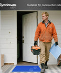 Man entering a building carrying tools and blueprints on Top Shelf Sticky Floor Mats At 24 By 36 Inches With Five Packs Providing Straight Up Dust Control And Quick Peel Sheets That Knock The Grit Right Out Whenever You Need It.