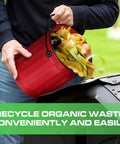 Person using Outdoor Dual Chamber 43 Gallon Compost Tumbler Kit With 1.5 Gallon Kitchen Bin Lid And Charcoal Filter Rotating Design