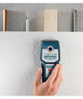 Professional Stud Finder Wall Scanner With Automatic Calibration To Nail Your Drywall Projects And Locate Rebar Pipes Plus Live Wires Using Hella Reliable Detection, being used on textured drywall surface.