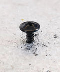 Close-up of a black truss head self-tapping screw, size 10 by 5/8 inch, crafted from heavy-duty stainless steel.