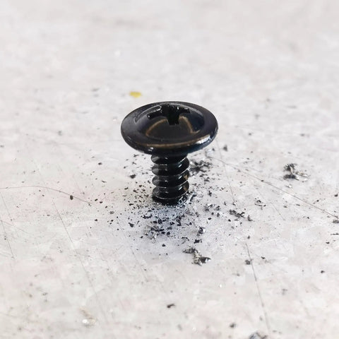 Close-up of a black truss head self-tapping screw, size 10 by 5/8 inch, crafted from heavy-duty stainless steel.