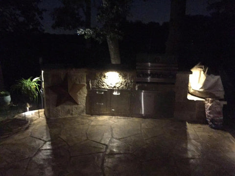 Outdoor area at night with Three LED Landscape Lights With Bracket In Textured Architectural Bronze Finish 4 Pack lighting a patio